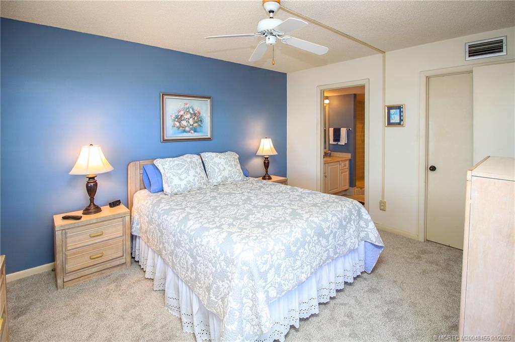 4540 Northeast Sandpebble Trace, Unit 302 Stuart, FL 34996 - Photo 17 of 34 a bedroom with bed and a lamp