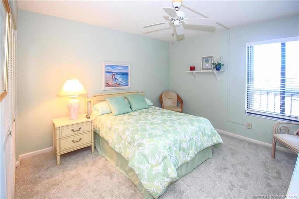 4540 Northeast Sandpebble Trace, Unit 302 Stuart, FL 34996 - Photo 21 of 34 a bedroom with a bed and a window