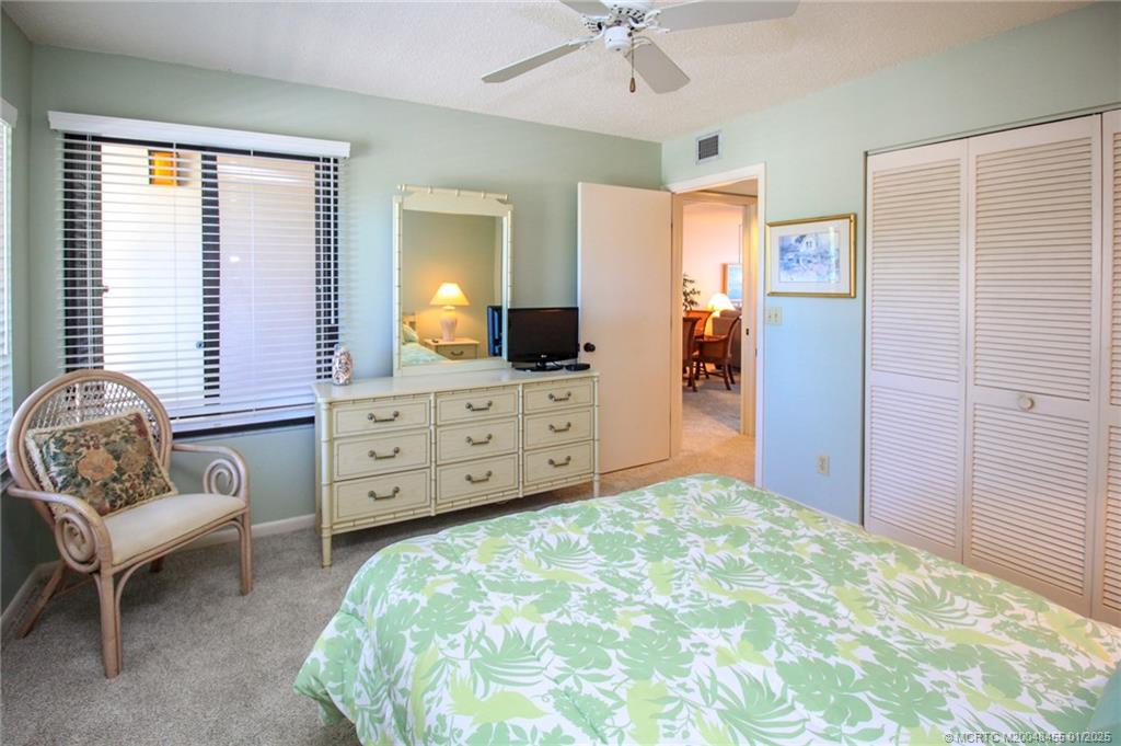 4540 Northeast Sandpebble Trace, Unit 302 Stuart, FL 34996 - Photo 22 of 34 a bedroom with a bed and a chair