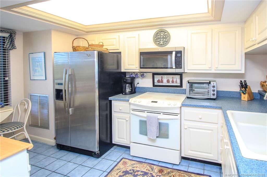 4540 Northeast Sandpebble Trace, Unit 302 Stuart, FL 34996 - Photo 5 of 34 a kitchen with stainless steel appliances granite countertop a refrigerator and a stove