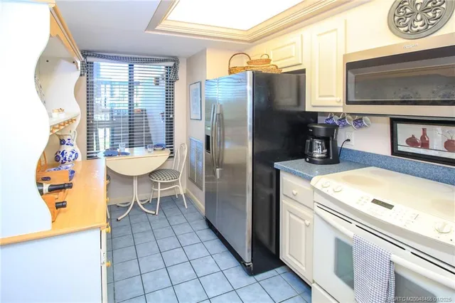 a kitchen with a refrigerator and a stove top oven