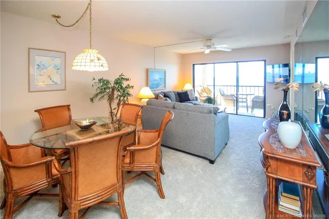 a dining room with furniture a large window and a chandelier