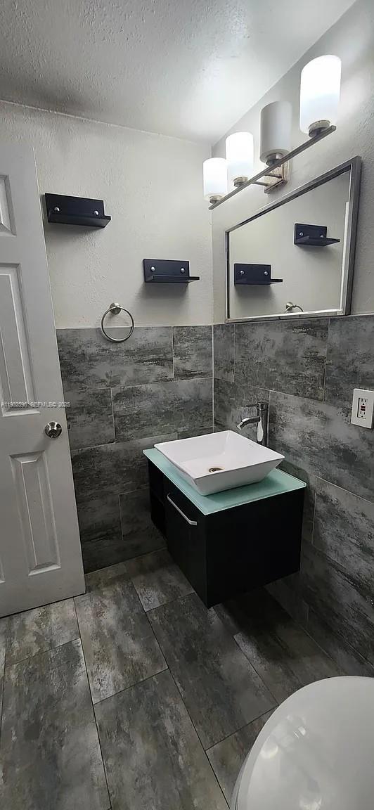 1 Northeast 78th Street, Unit B Miami, FL 33138 - Photo 5 of 8 a bathroom with a sink and a mirror