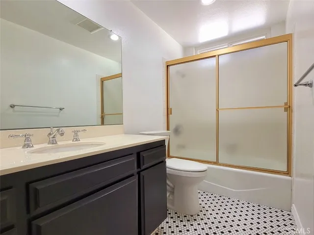 a bathroom with a sink a toilet a shower and a mirror