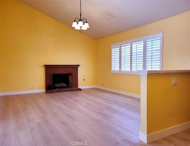 a view of an empty room with a window and fireplace