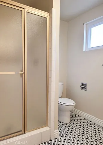 a bathroom with a toilet and a shower