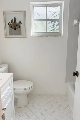 a white toilet sitting next to a bathroom sink
