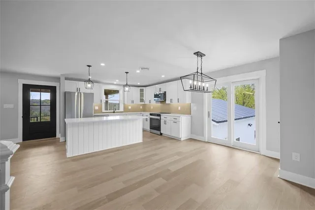 a view of kitchen with granite countertop lots of counter top space and stainless steel appliances
