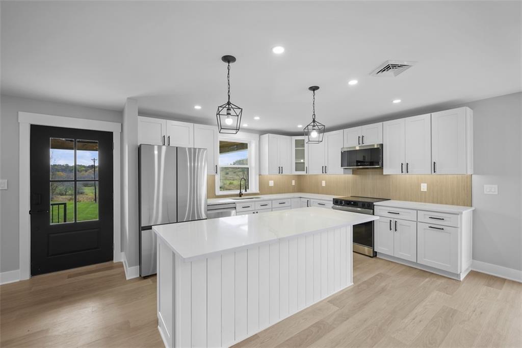 134 Kings Creek Road Georgetown, PA 15043 - Photo 12 of 44 a large kitchen with stainless steel appliances kitchen island granite countertop a stove a sink a refrigerator and a granite counter tops with white cabinets