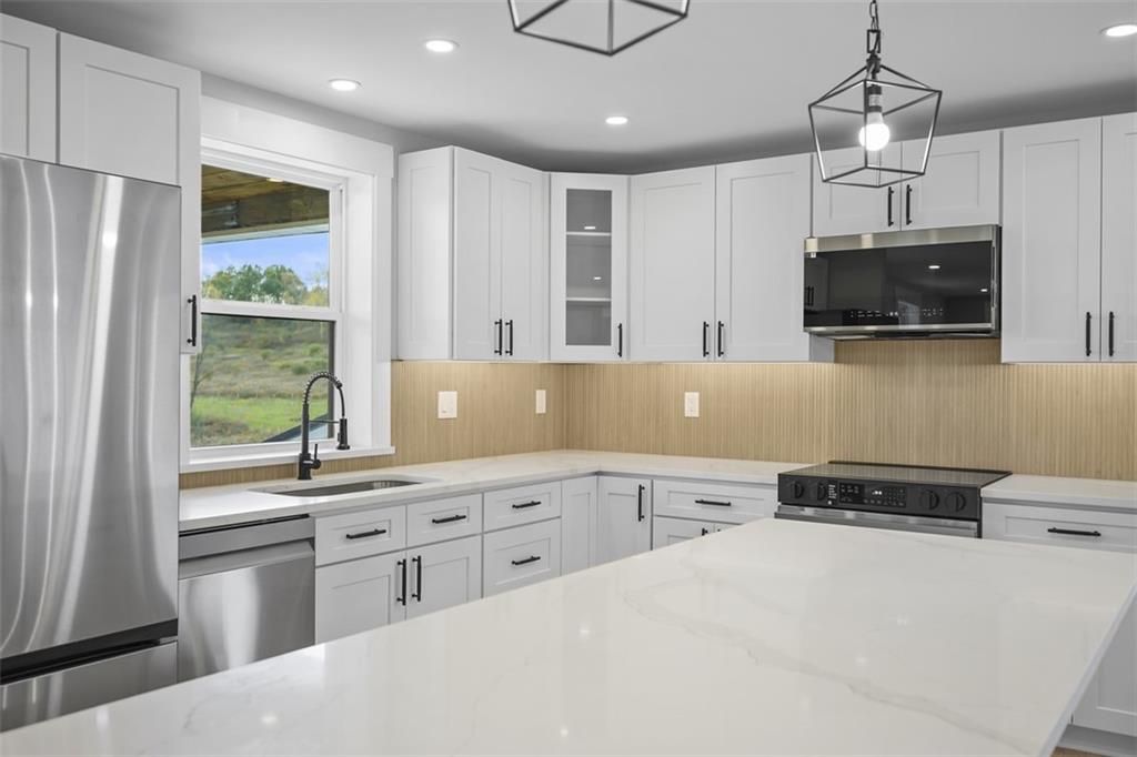 134 Kings Creek Road Georgetown, PA 15043 - Photo 14 of 44 a kitchen with a sink a counter top space stainless steel appliances and cabinets