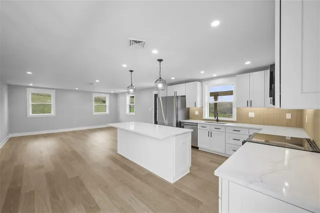 a large white kitchen with cabinets a sink and a stove