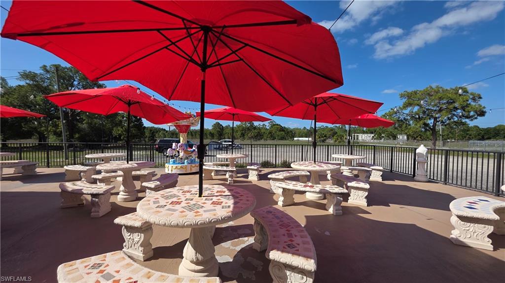 612 Hunting Clb Avenue Montura Ranches, FL 33440 - Photo 38 of 49 a view of a patio with couches table and chairs under an umbrella