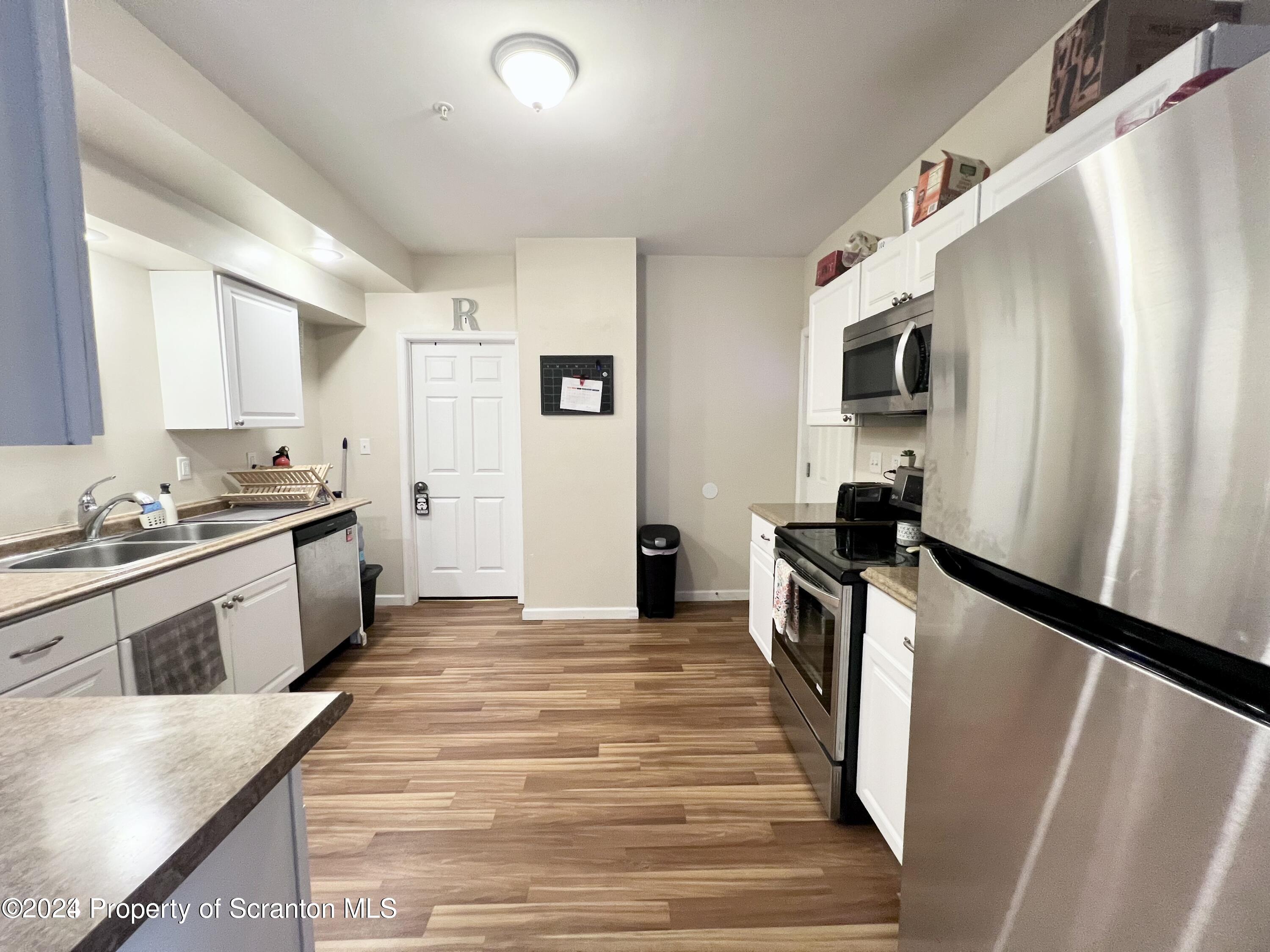 721 Columbia Street, Unit A Scranton, PA 18509 - Photo 3 of 12 a kitchen with granite countertop a refrigerator and a sink