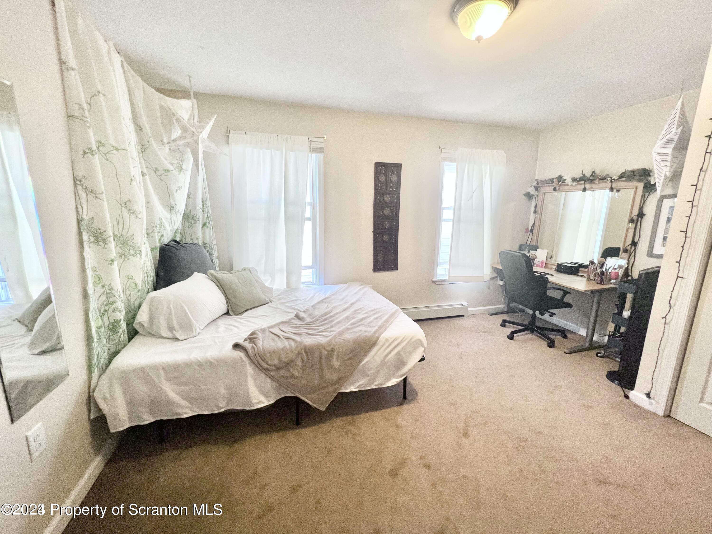 721 Columbia Street, Unit A Scranton, PA 18509 - Photo 7 of 12 a spacious bedroom with a bed and a couch