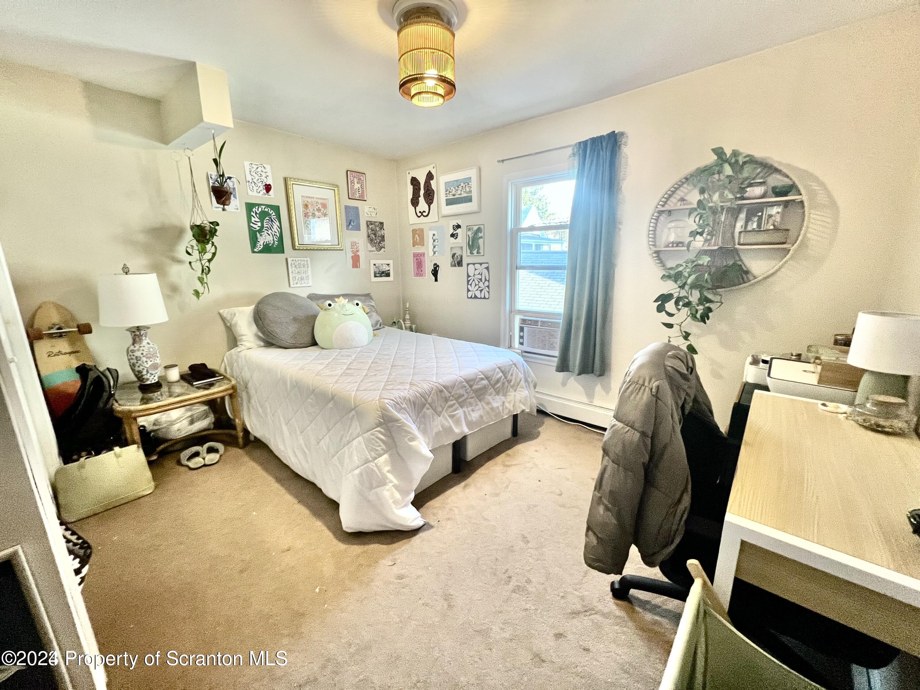 721 Columbia Street, Unit A Scranton, PA 18509 - Photo 8 of 12 a bedroom with a bed and a chandelier