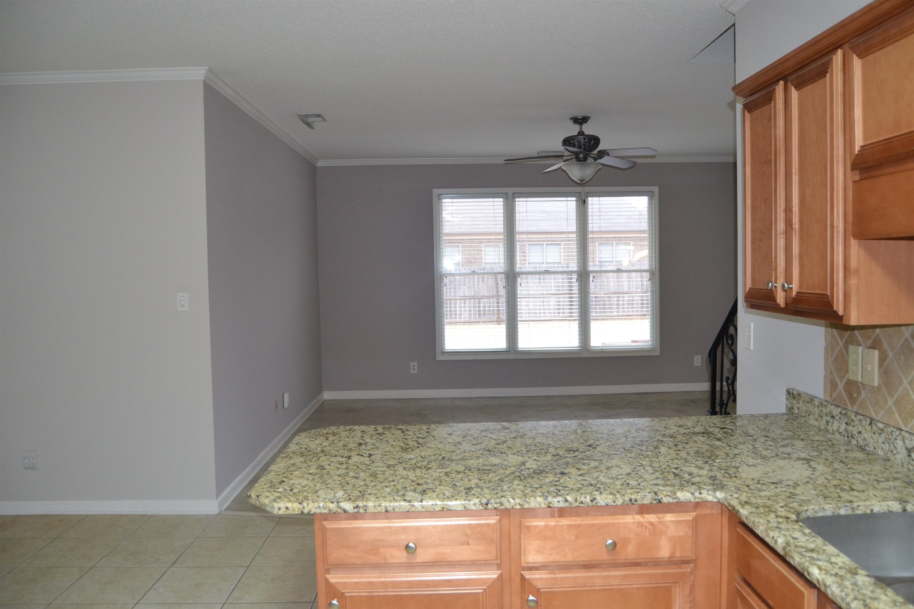 10486 Juneau Way Collierville, TN 38017 - Photo 17 of 33 Kitchen with kitchen peninsula, light stone counters, ceiling fan, and crown molding