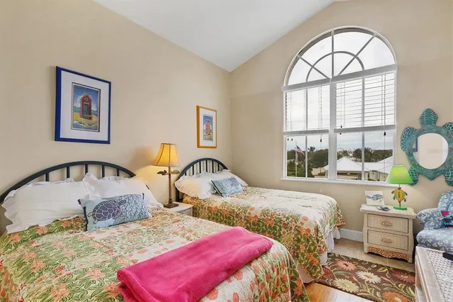 a bedroom with two beds and a large mirror on the dresser