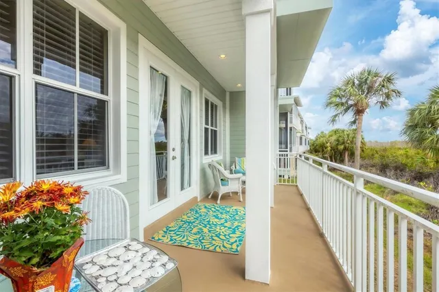 a view of a porch with a table and chairs and potted plants