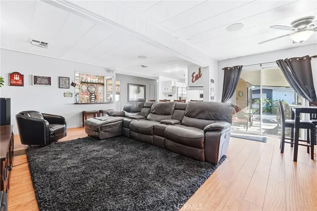 a living room with furniture wooden floor and a large window