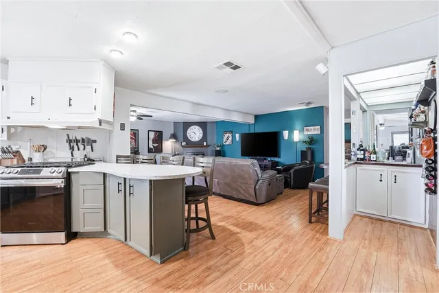 a living room with stainless steel appliances kitchen island granite countertop a sink and cabinets