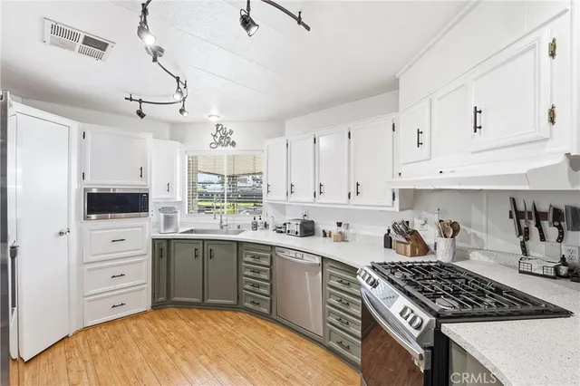 a kitchen with stainless steel appliances a sink stove and cabinets