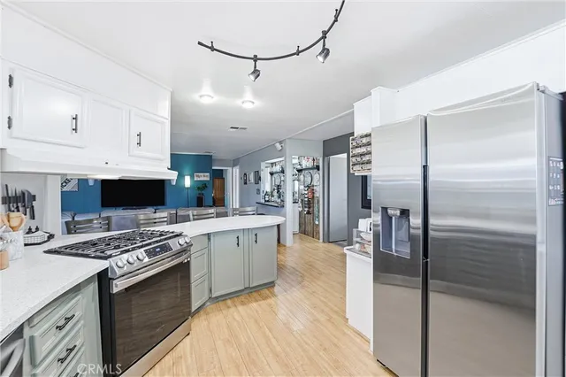 a kitchen with stainless steel appliances granite countertop a stove top oven a sink and a refrigerator