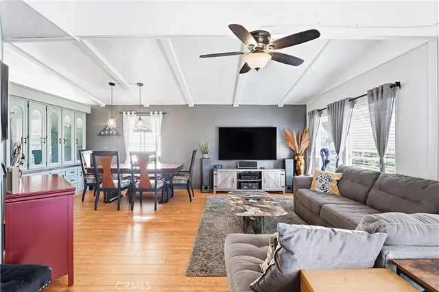 a living room with furniture kitchen view and a flat screen tv