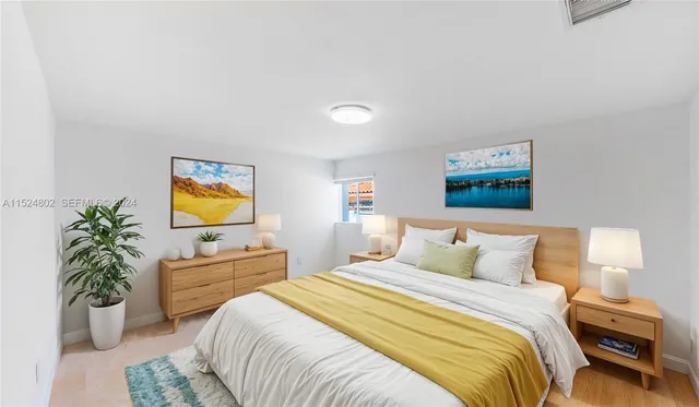 a bedroom with a bed and a potted plant