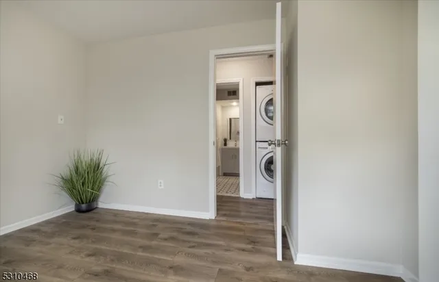 a view of a hallway with wooden floor and a potted plant