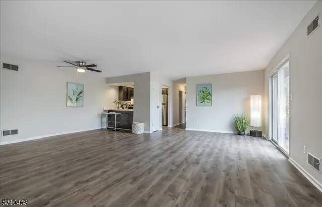 a view of a livingroom with wooden floor and staircase