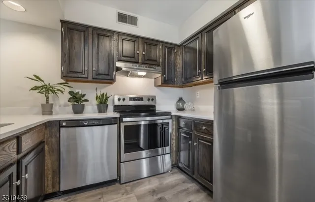 a kitchen with stainless steel appliances and wooden cabinets
