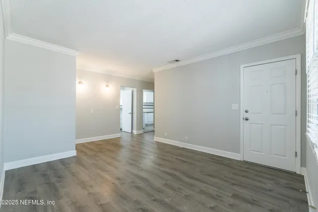 a view of an empty room with wooden floor