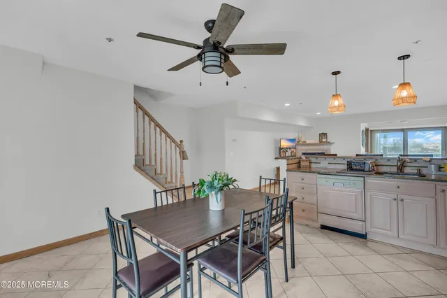 a kitchen with a dining table chairs and white cabinets