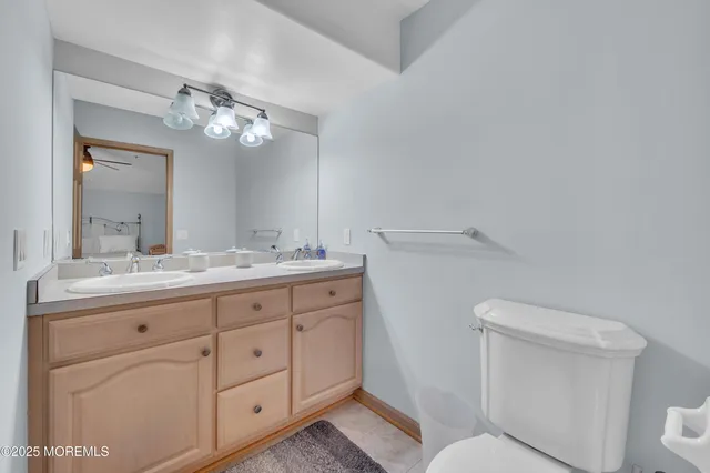 a bathroom with a granite countertop toilet sink and mirror