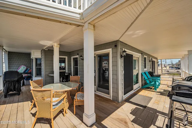 a roof deck with a table and chairs and potted plants