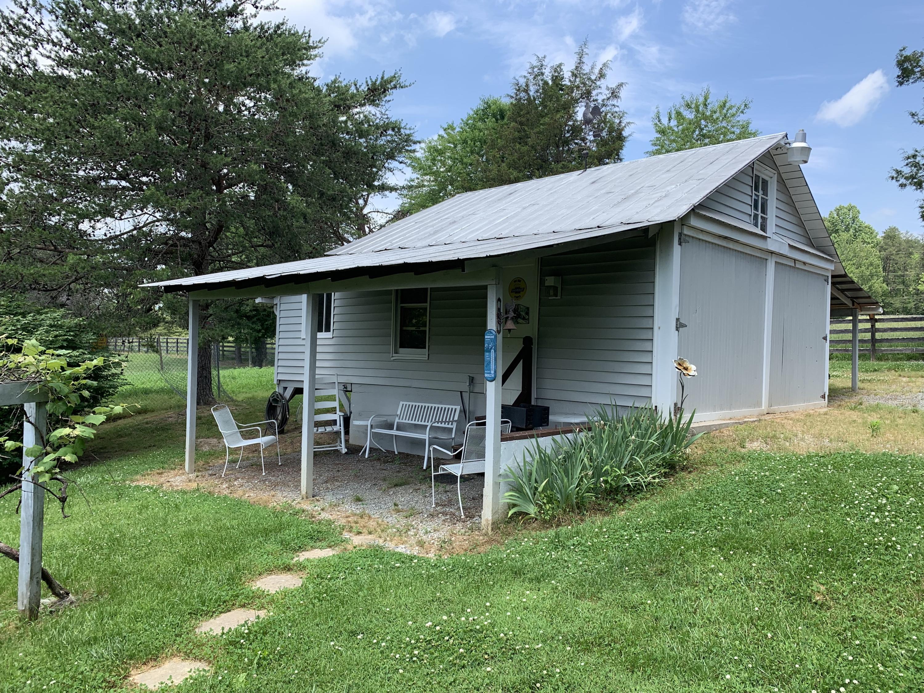 1763 Morgans Mill Road Goodview, VA 24095 - Photo 27 of 46 a backyard of a house with table and chairs potted plants and large tree