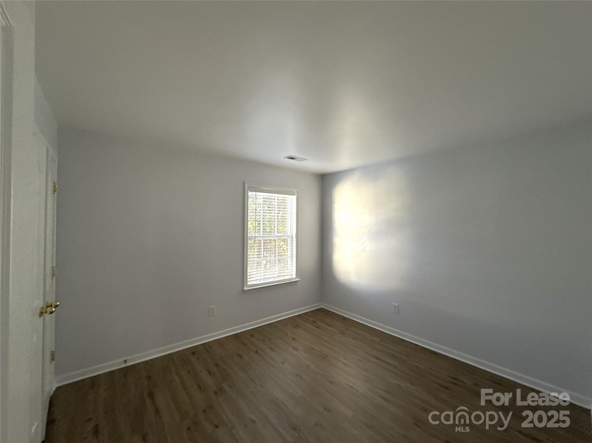 3415 Cole Mill Road Charlotte, NC 28270 - Photo 12 of 18 an empty room with wooden floor and windows