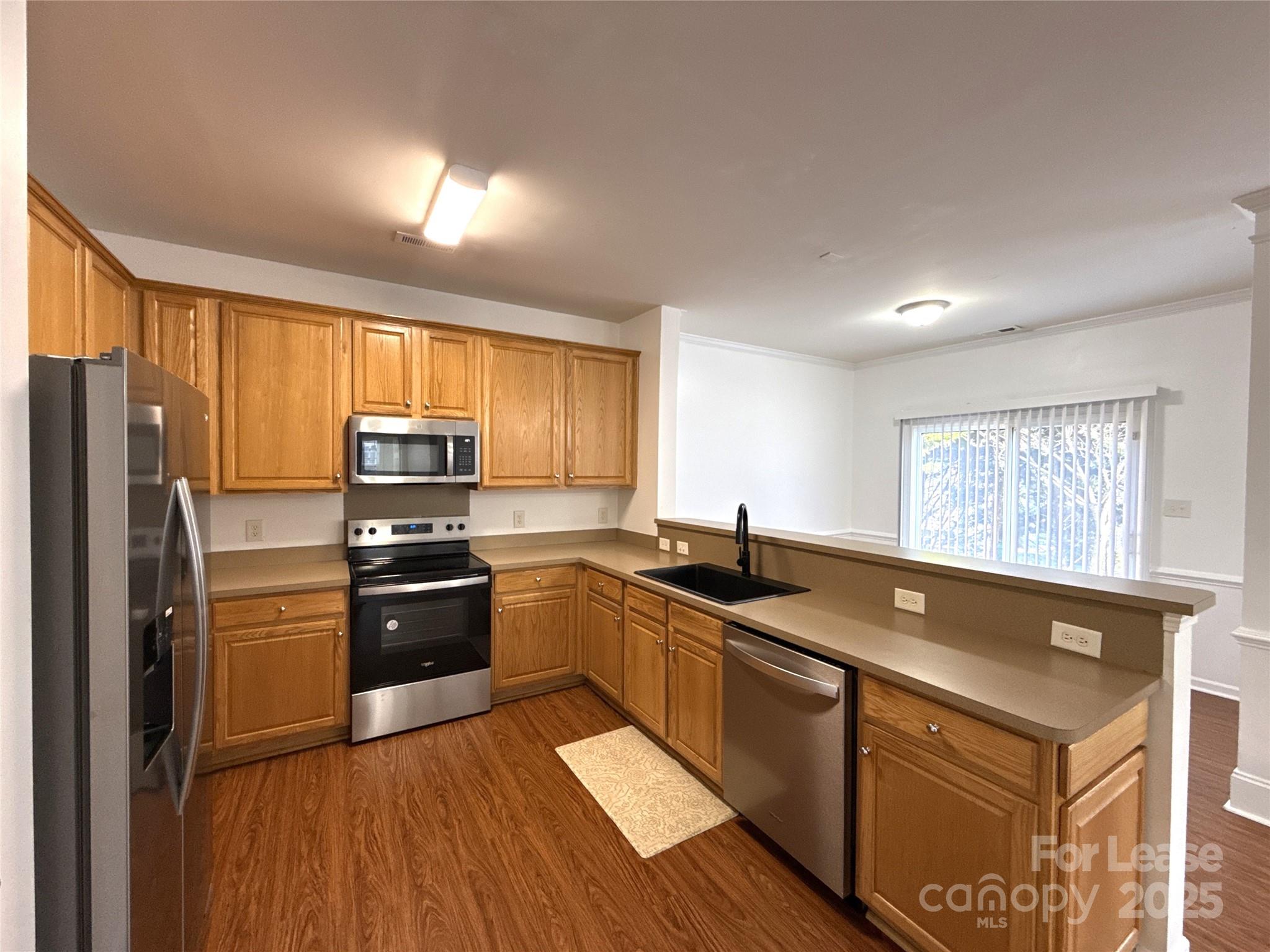 3415 Cole Mill Road Charlotte, NC 28270 - Photo 3 of 18 a kitchen with granite countertop a sink stove refrigerator and wooden cabinets