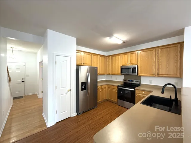 a kitchen with stainless steel appliances granite countertop a refrigerator sink and stove