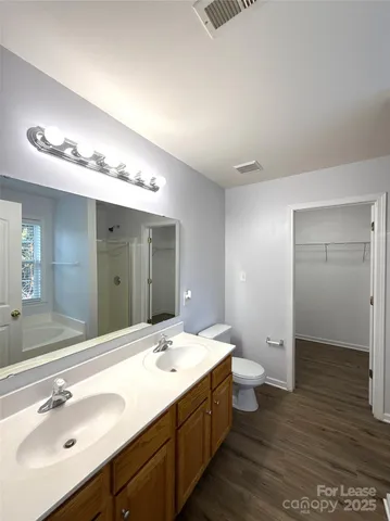 a bathroom with a double vanity sink mirror and toilet