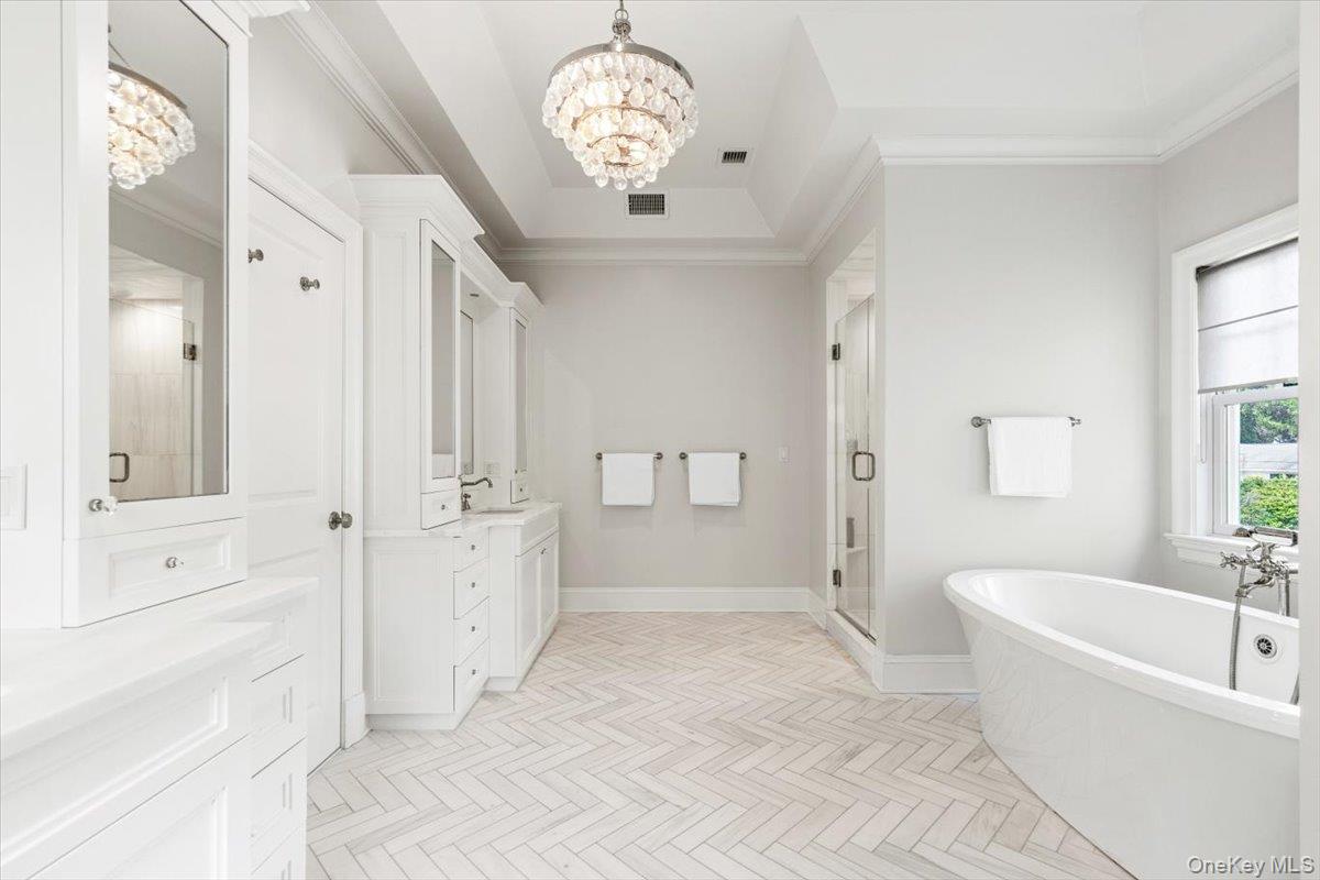 81 Wappanocca Avenue Rye, NY 10580 - Photo 13 of 27 Full bath with a chandelier, vanity, a shower stall, a freestanding bath, and crown molding
