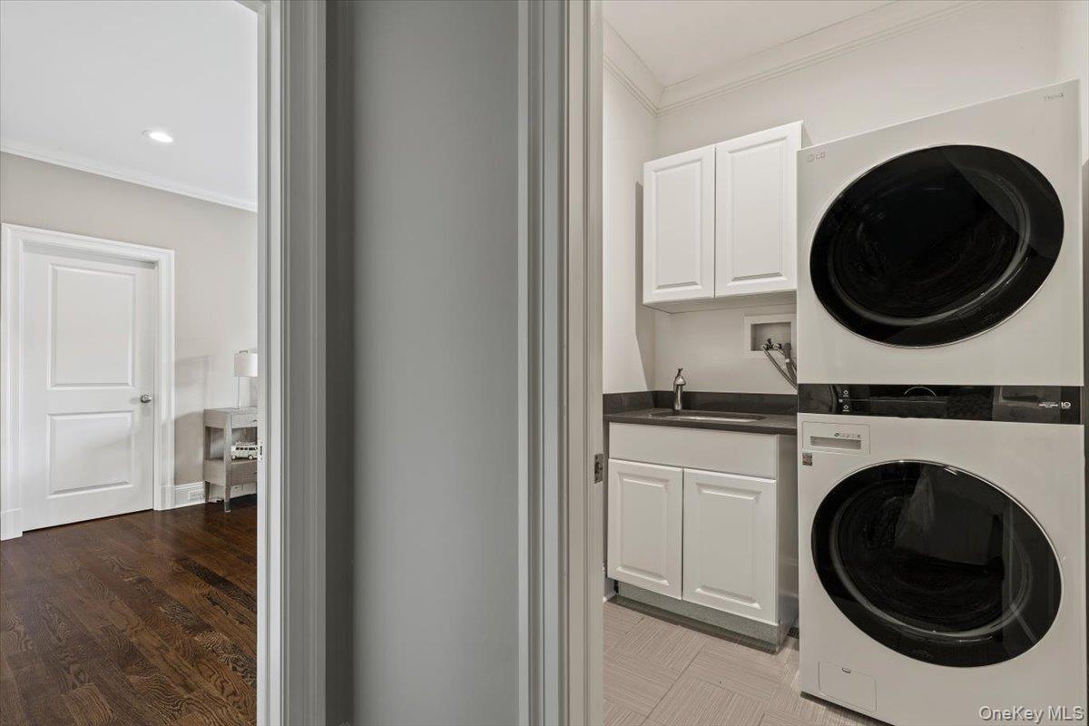 81 Wappanocca Avenue Rye, NY 10580 - Photo 17 of 27 Laundry room with stacked washer and clothes dryer, cabinet space, ornamental molding, bar with sink, and recessed lighting