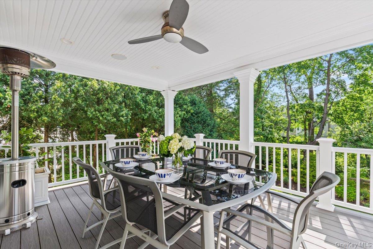 81 Wappanocca Avenue Rye, NY 10580 - Photo 19 of 27 Wooden terrace featuring outdoor dining space, a ceiling fan, and view of wooded area