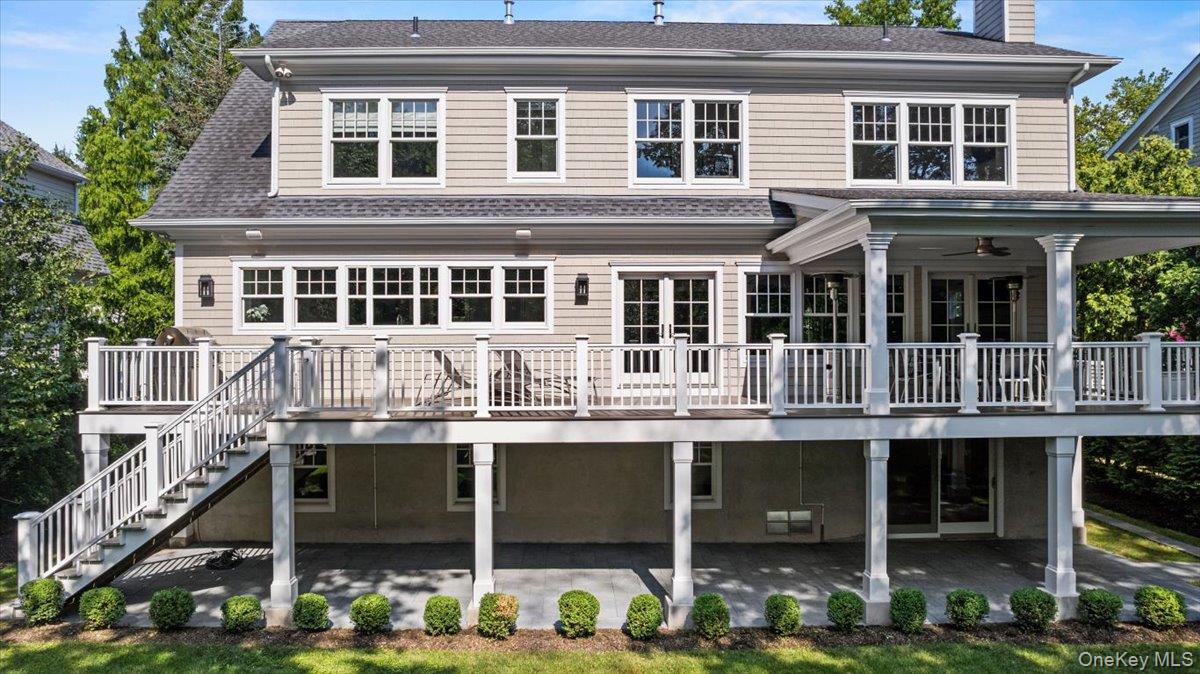 81 Wappanocca Avenue Rye, NY 10580 - Photo 23 of 27 Rear view of property featuring a patio, a deck, a shingled roof, a chimney, and stairs