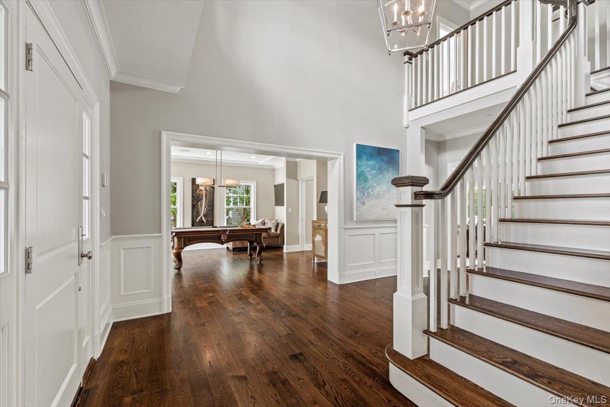 81 Wappanocca Avenue Rye, NY 10580 - Photo 3 of 27 Entrance foyer with a decorative wall, stairs, crown molding, wood finished floors, and a high ceiling