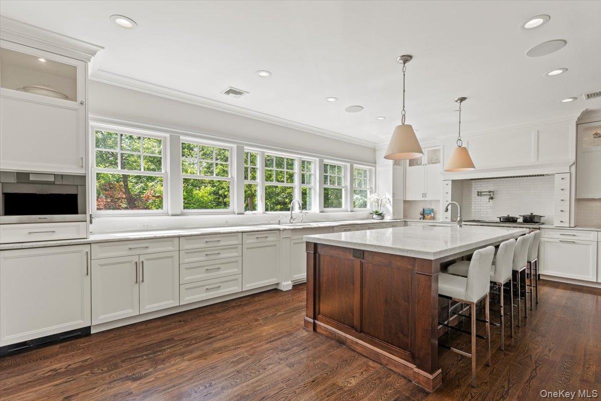81 Wappanocca Avenue Rye, NY 10580 - Photo 8 of 27 Kitchen featuring white cabinets, dark wood-type flooring, recessed lighting, backsplash, and glass insert cabinets