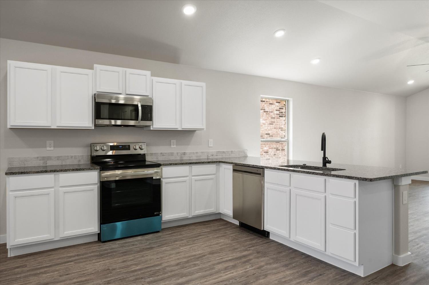 8622 26th Street Lubbock, TX 79407 - Photo 14 of 16 a kitchen with sink a microwave and cabinets