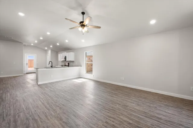 a view of a kitchen with a sink a ceiling fan and wooden floor