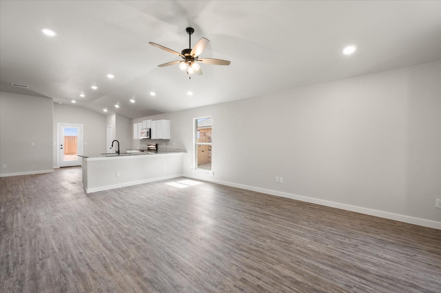 8622 26th Street Lubbock, TX 79407 - Photo 15 of 16 a view of a kitchen with a sink a ceiling fan and wooden floor