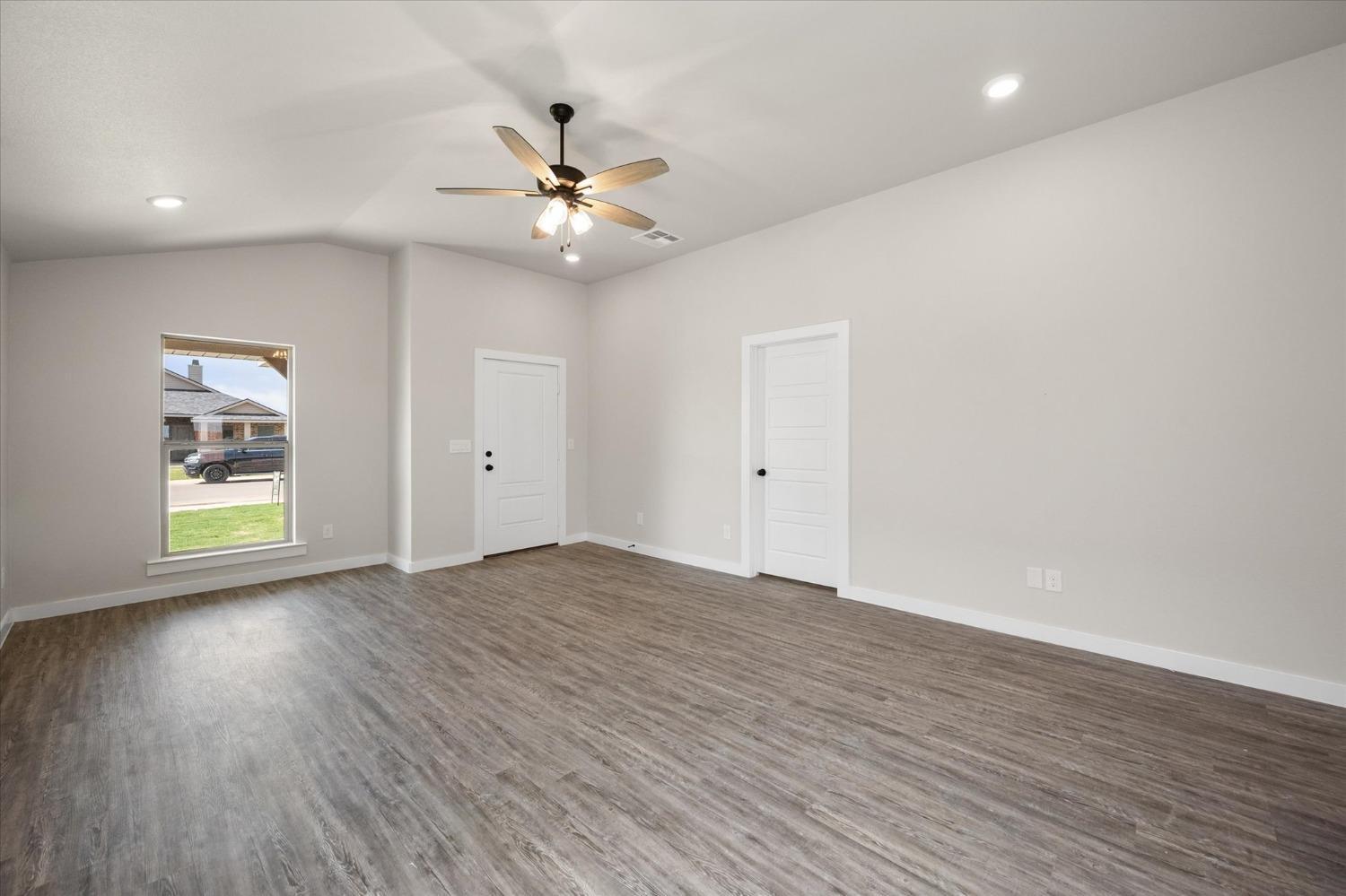 8622 26th Street Lubbock, TX 79407 - Photo 3 of 16 a view of an empty room with a window and wooden floor